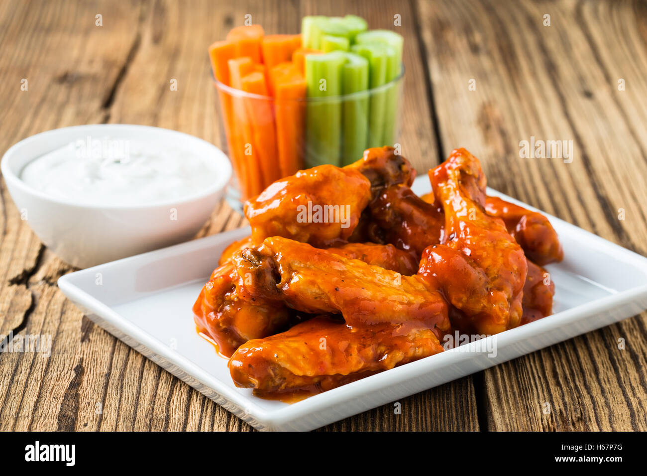 Buffalo chicken wing with cayenne pepper  sauce served hot with celery sticks and carrot sticks with blue cheese dressing Stock Photo