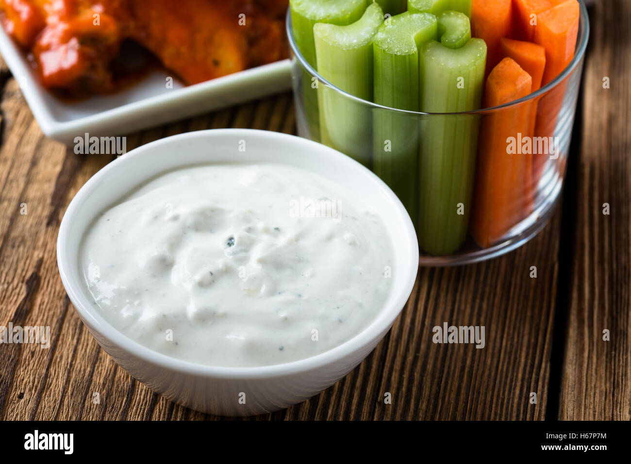 Blue cheese dressing for dipping served with celery sticks, carrot