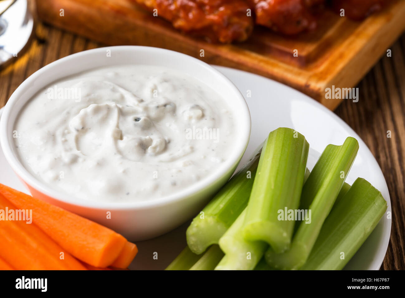 Blue cheese dressing for dipping served with celery sticks, carrot