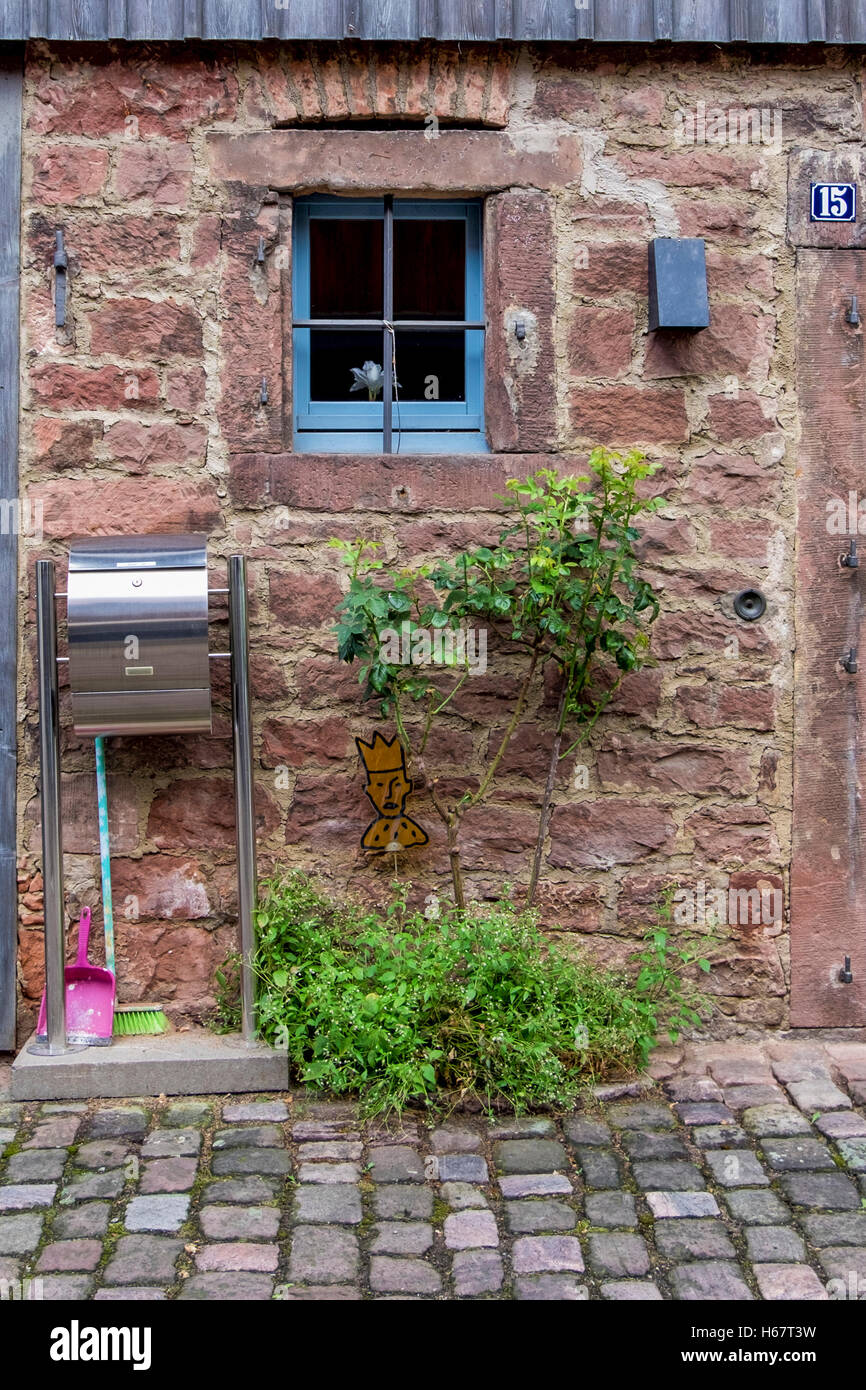 Cleaning materials at entrance of pretty stone cottage. Michelstadt, Southern Hesse, Germany Stock Photo