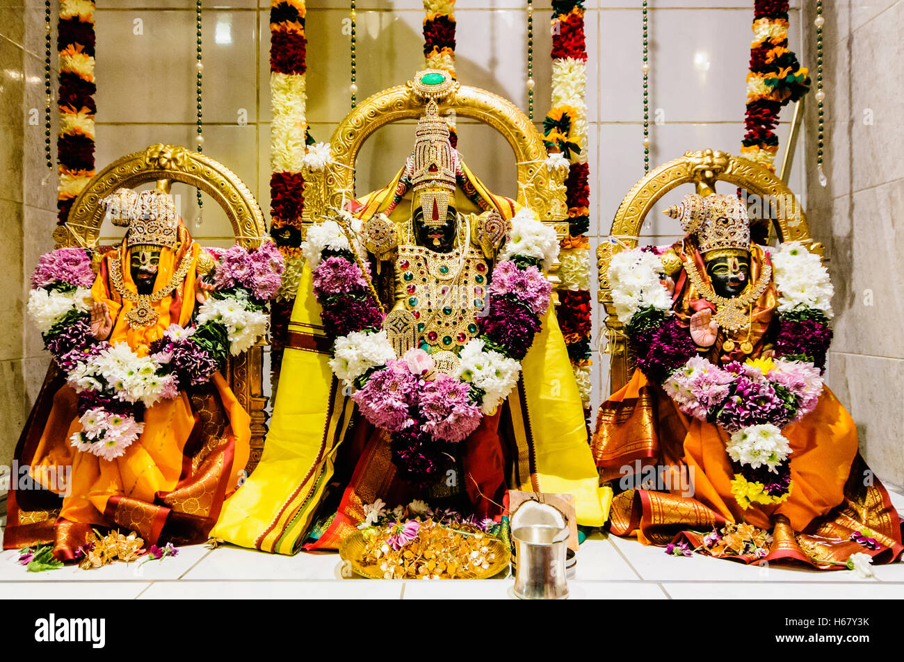 Ornate Hindu Deities and gifts at the altar of a Temple Stock Photo Alamy