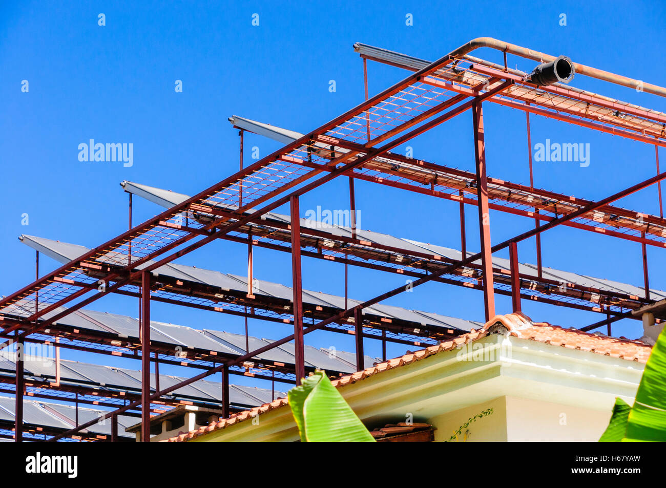 Solar panels on a metal frame on the roof of a building in a hot climate Stock Photo