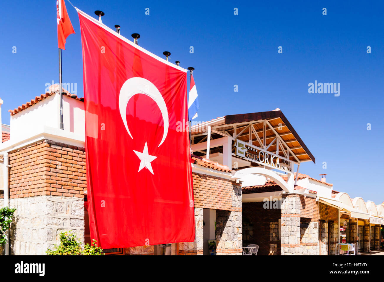 Red Turkish flag hanging outside the Orka Club hotel in Hisaronu, Turkey. Stock Photo