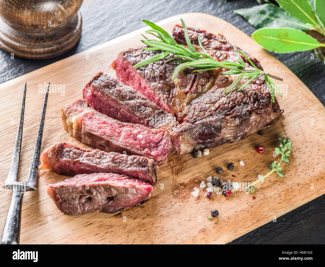 Medium Ribeye steak with spices on the wooden tray Stock Photo - Alamy