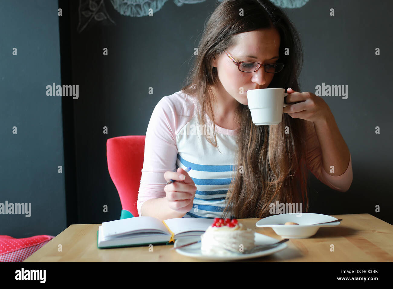 girl in a cafe for a cup of coffee with the notebook Stock Photo