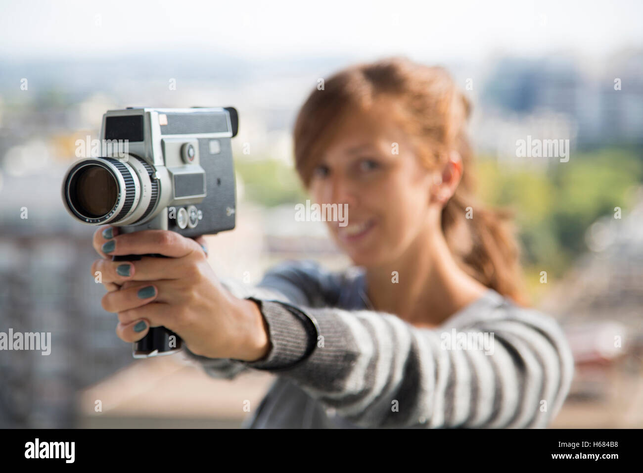 Young woman filming with vintage motion camera Stock Photo