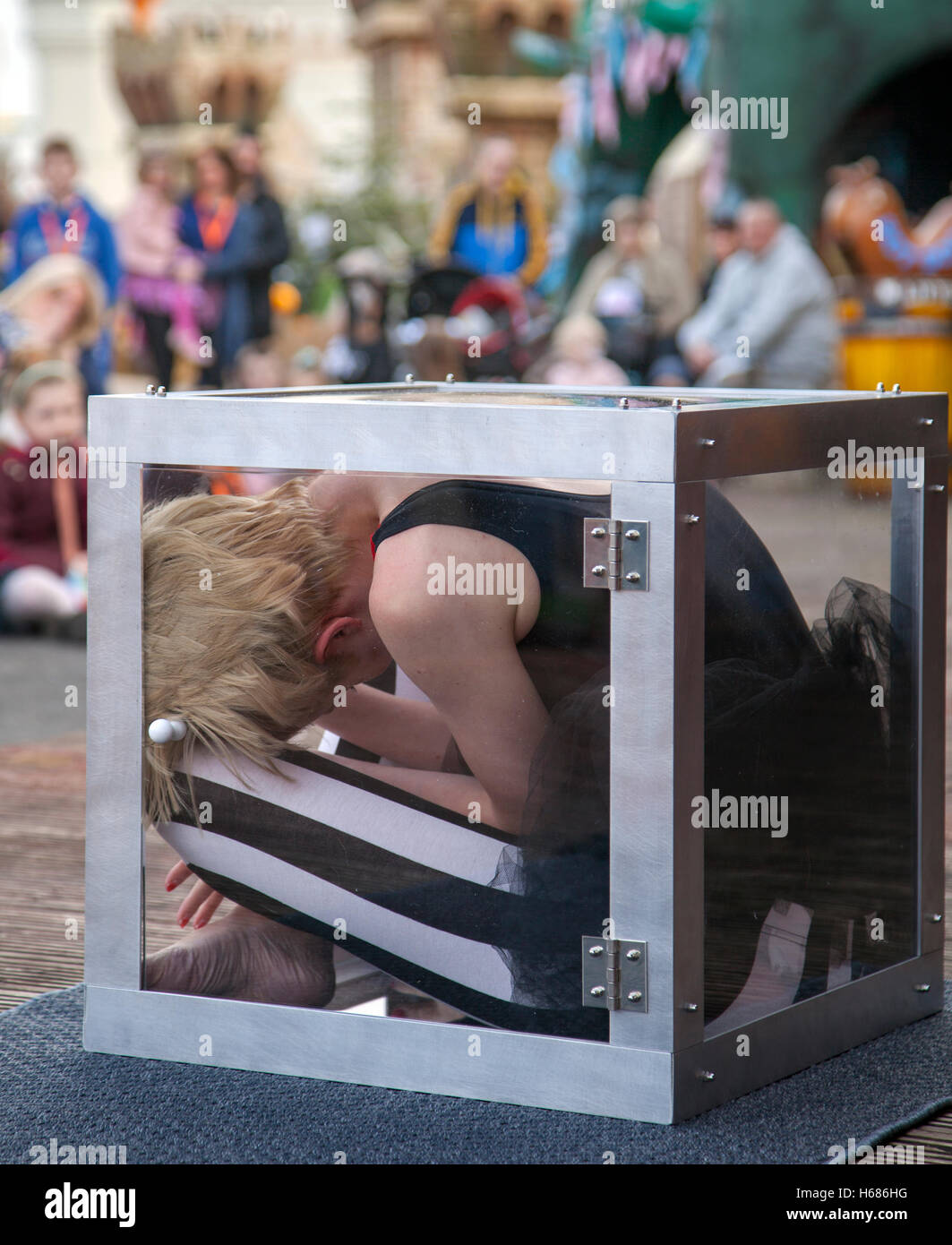 Circus contortionists squeeze into a small glass Cube at Southport. A ...