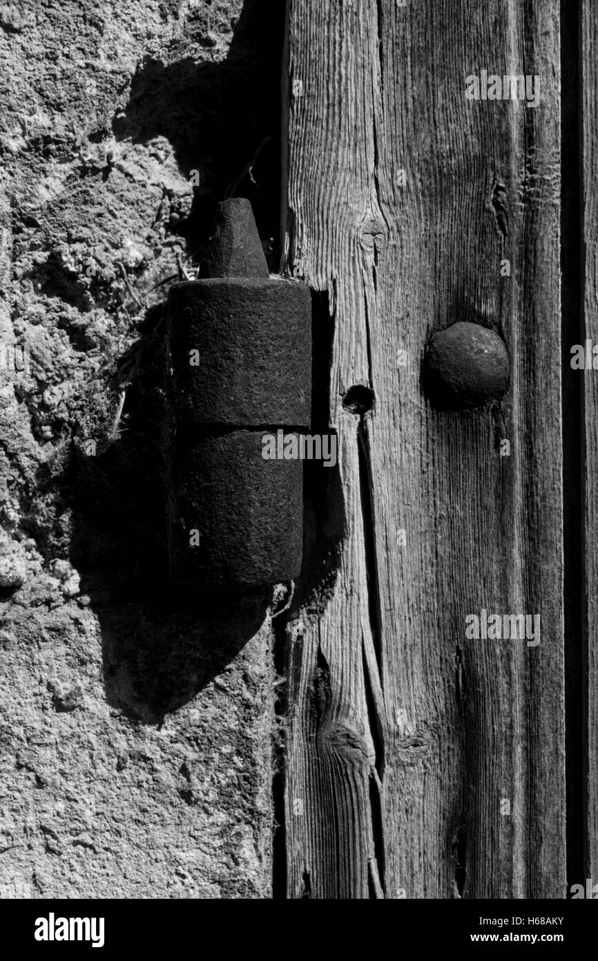 rusted aged hinge of wooden door holding it to stone wall of a church