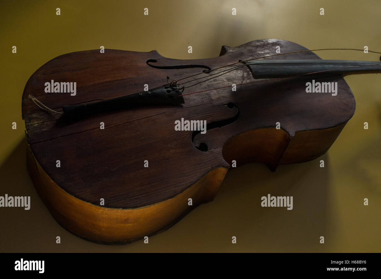 Old worn vintage cello hanging on yellow wall Stock Photo Alamy