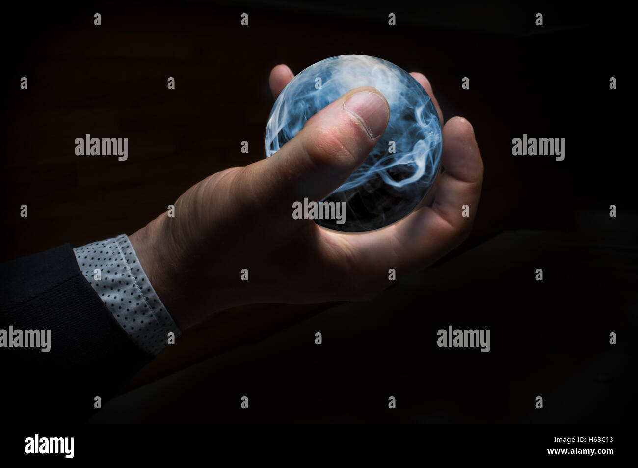 Hand holding magic crystal ball filled with smoke Stock Photo - Alamy