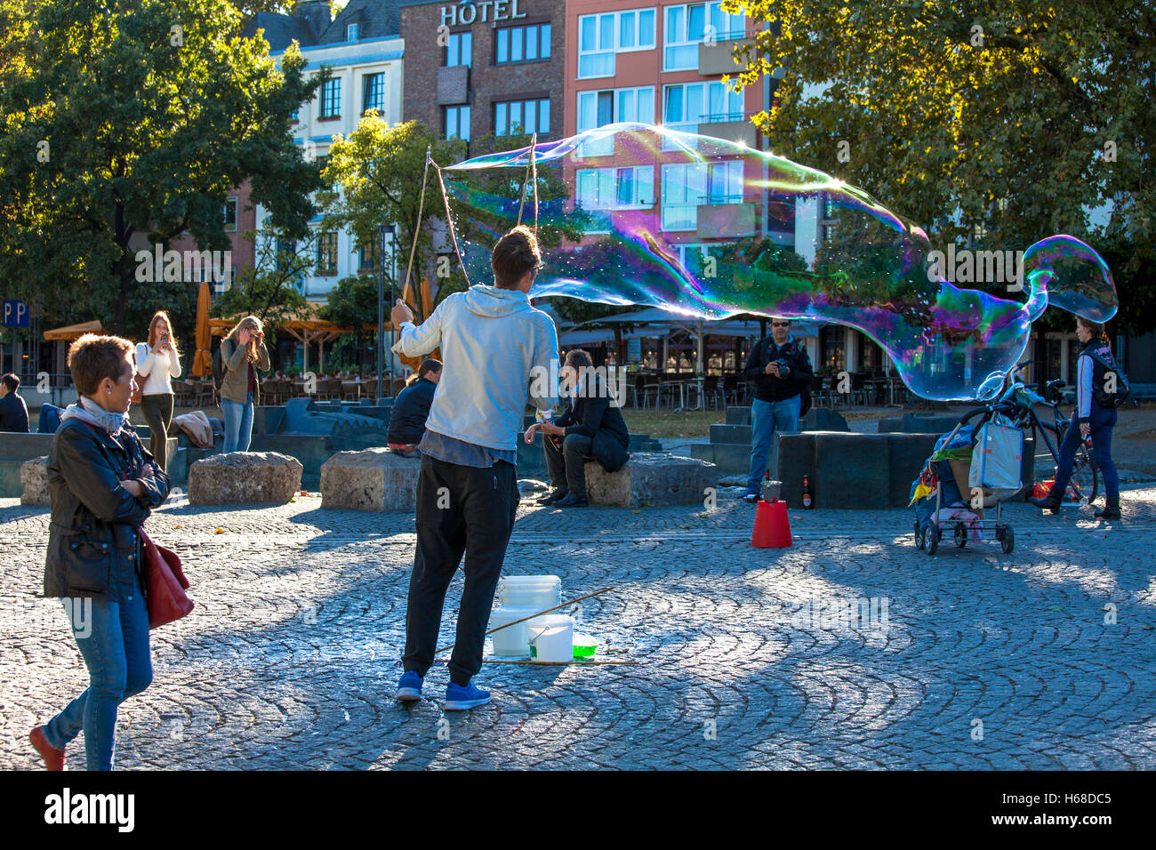 Germany, Cologne, man makes soap bubbles at the Rhine garden in the old part of the town. Stock Photo