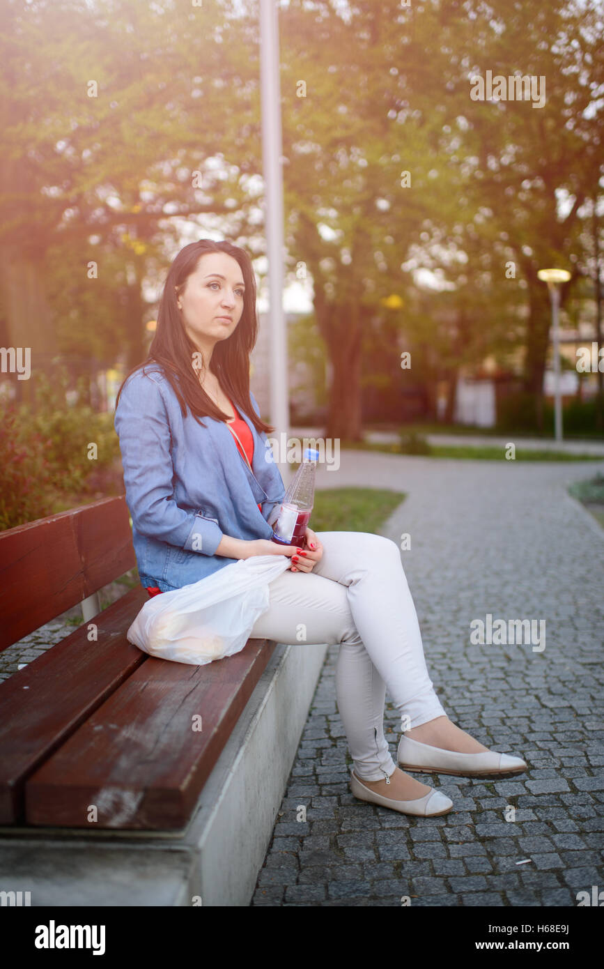 The beautiful young city woman sits on a bench in the city Stock Photo ...