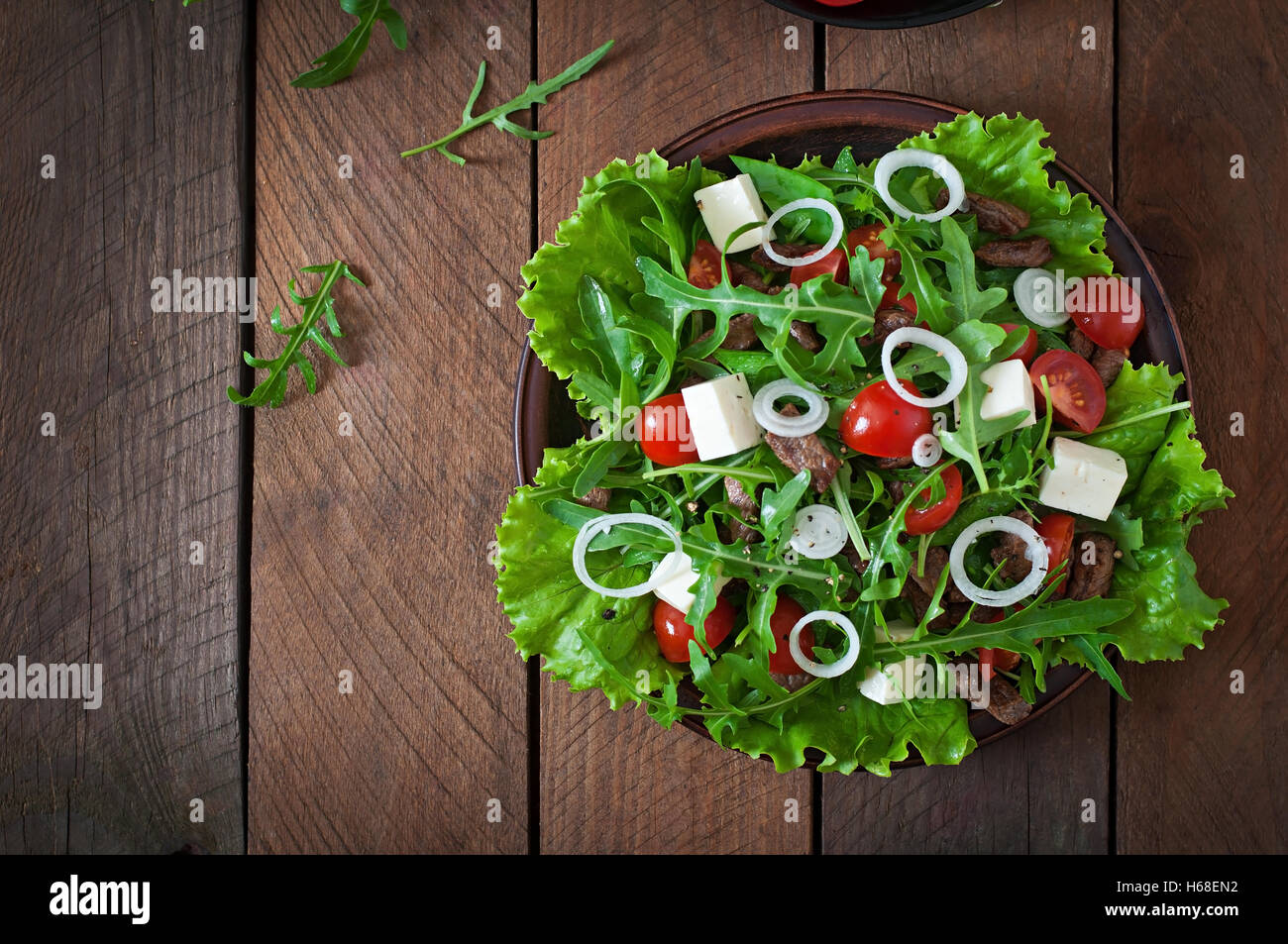 Salad with veal slices, arugula, tomatoes and feta cheese Stock Photo