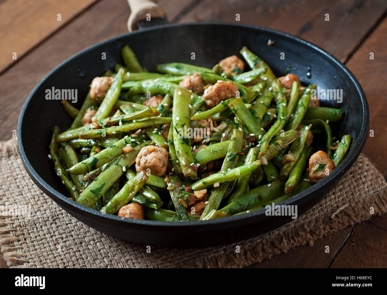 Green beans fried with chicken meatballs and garlic Asian style. Stock Photo