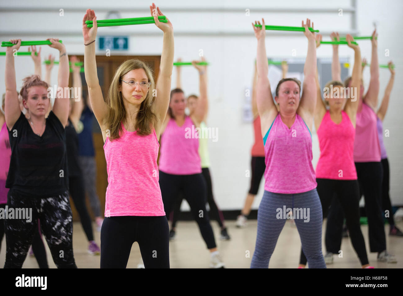 Women participating in POUND fitness class, hour long workout drumming