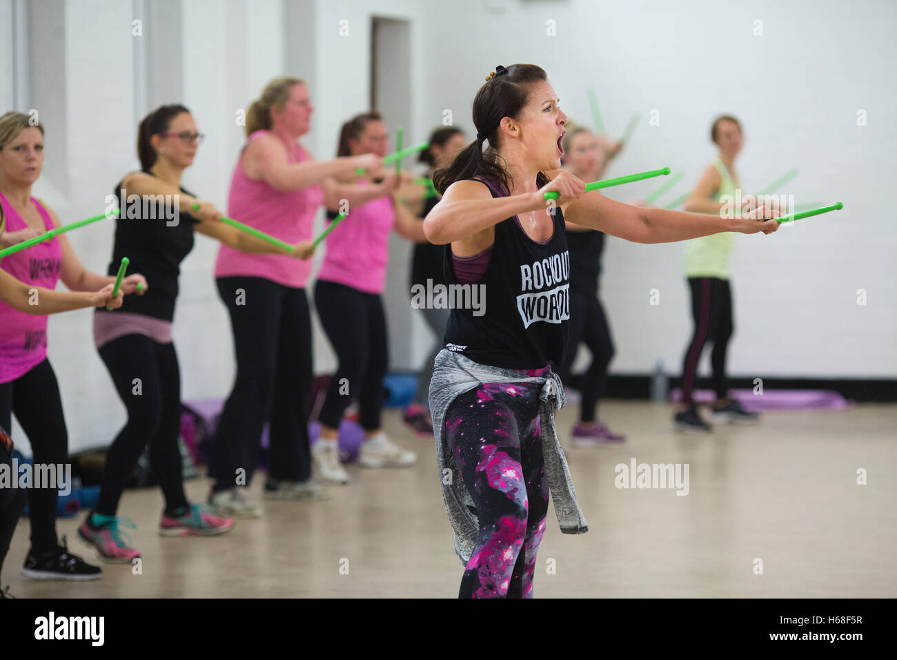 Women participating in POUND fitness class, hour long workout drumming