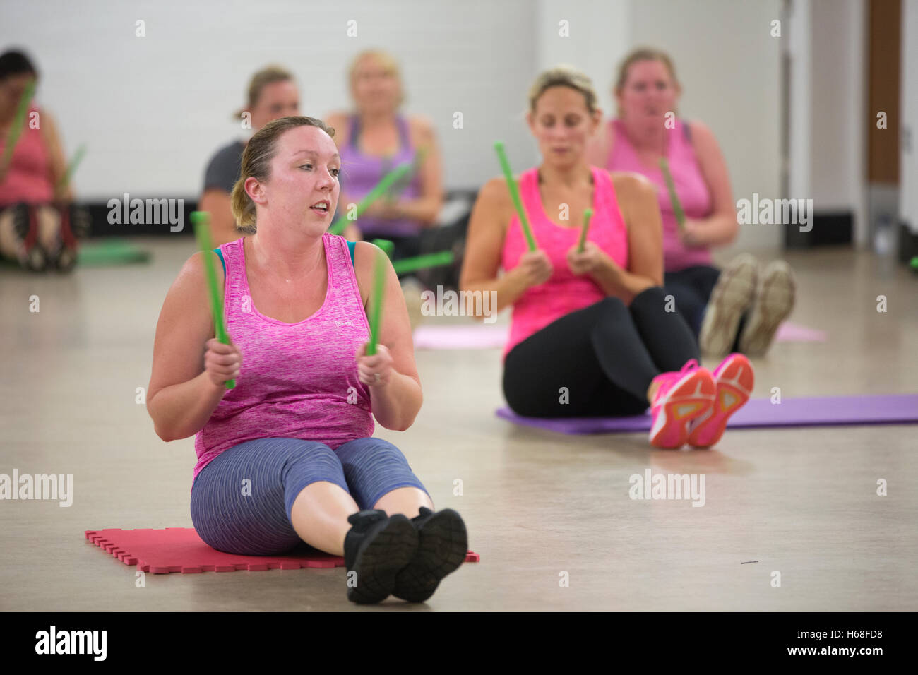 Women participating in POUND fitness class, hour long workout drumming which increases core