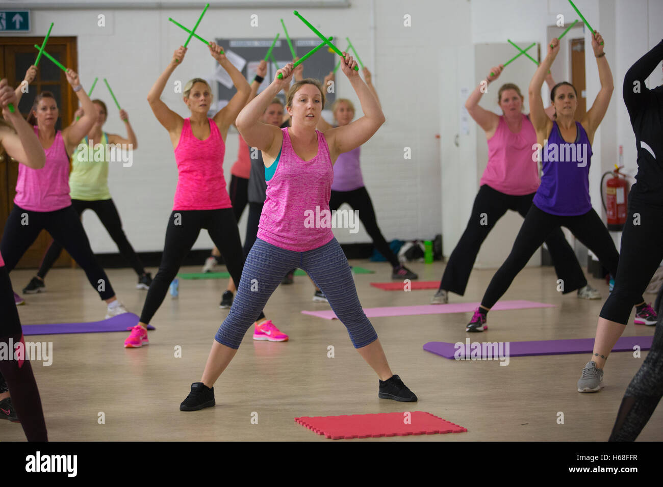 Women participating in POUND fitness class, hour long workout drumming