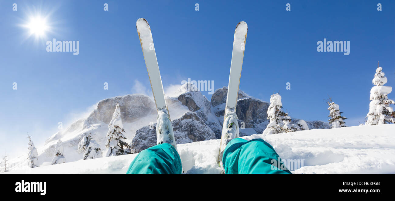 Detail of alpine skier legs, watching the valley panorama. Winter equipment, vacation concept, copyspace for text Stock Photo