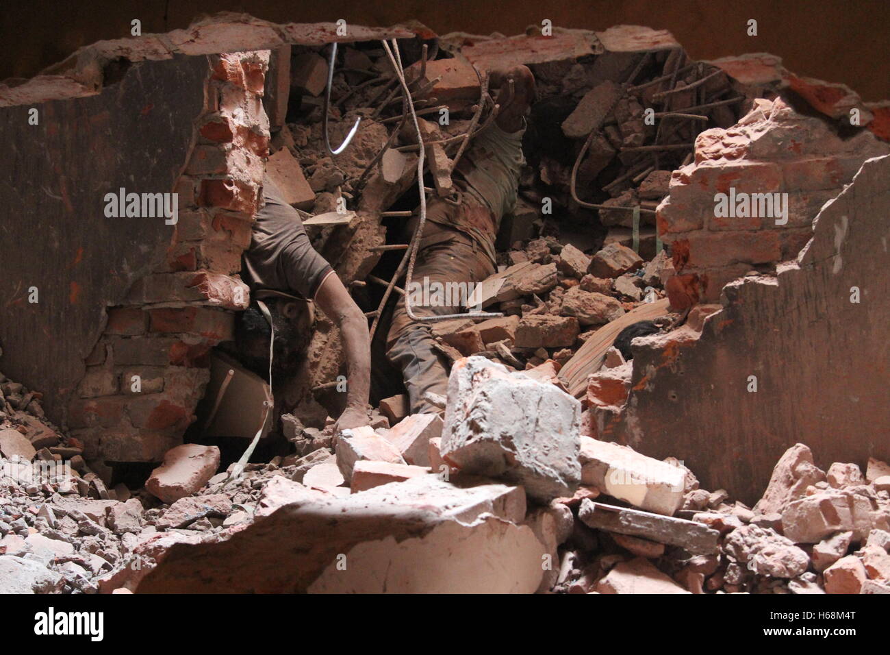 The body of a garment worker is seen amongst the rubble of the ...