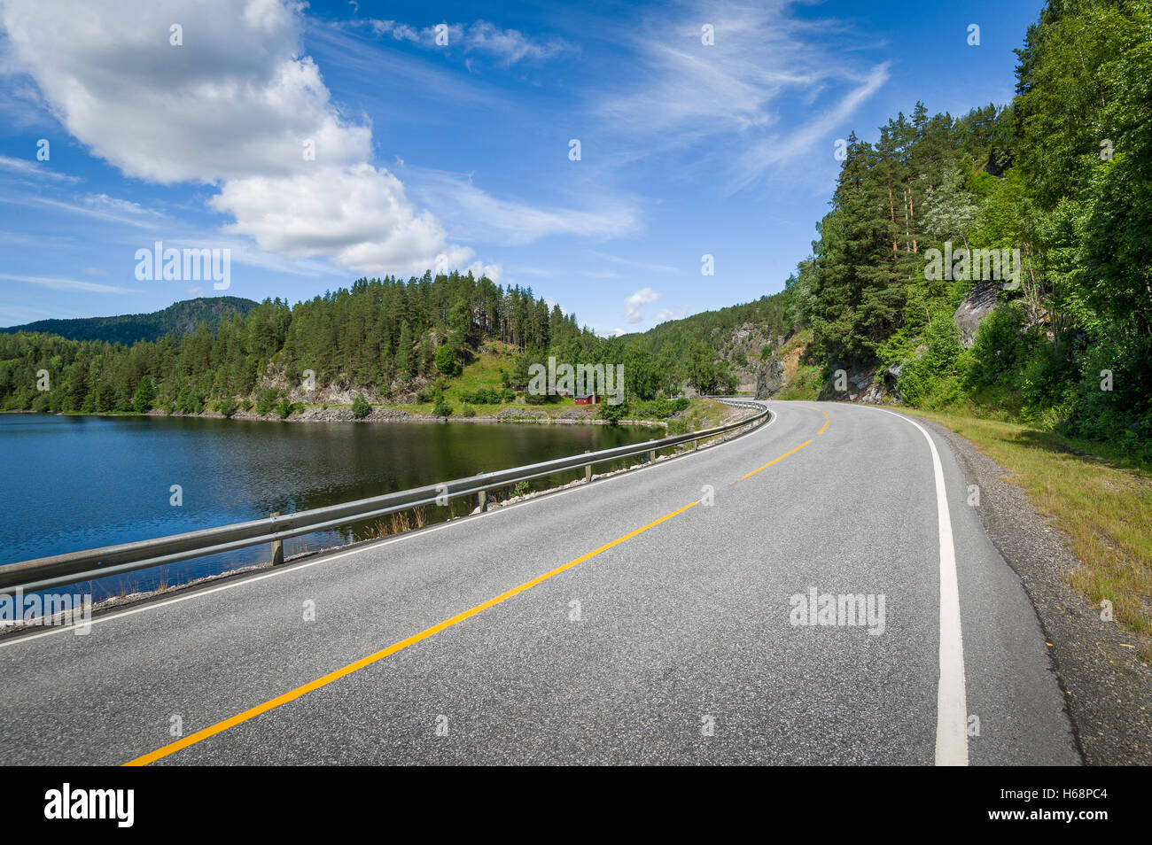 Empty curved road on the lake's shore in Norway Stock Photo