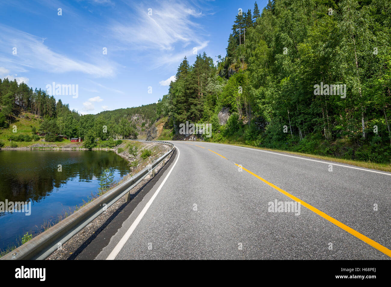 Country landscape with lake's shore and empty highway road. Stock Photo