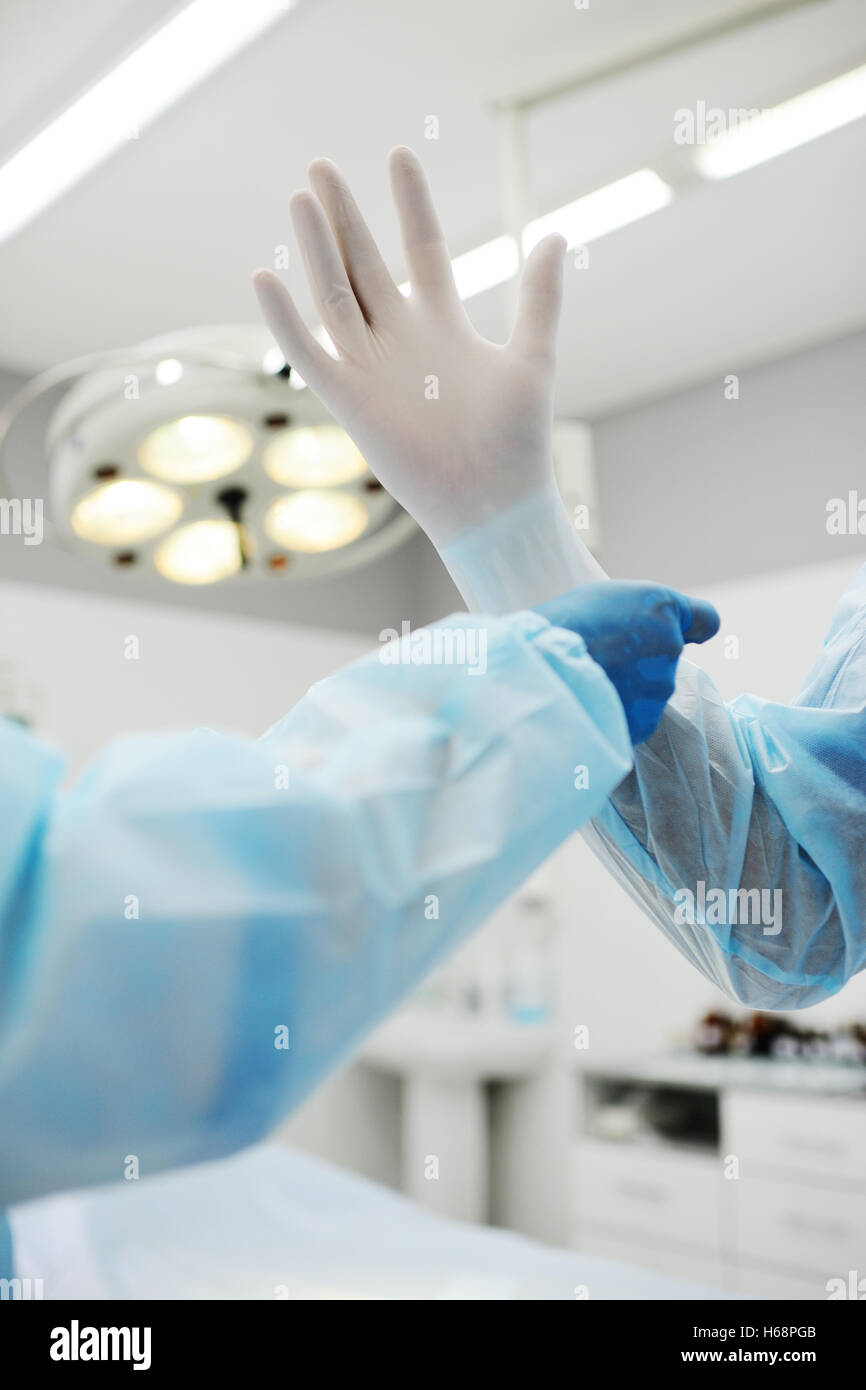 Assistant helps the surgeon put on latex gloves Stock Photo Alamy