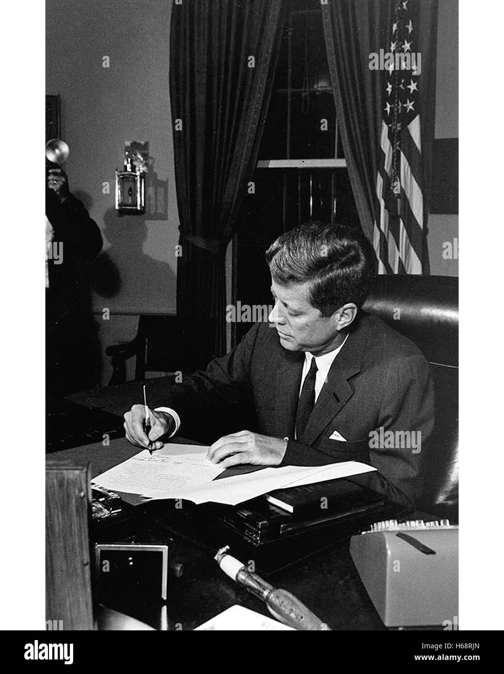 President John F. Kennedy signs legislation in the Oval Office at the White House Stock Photo
