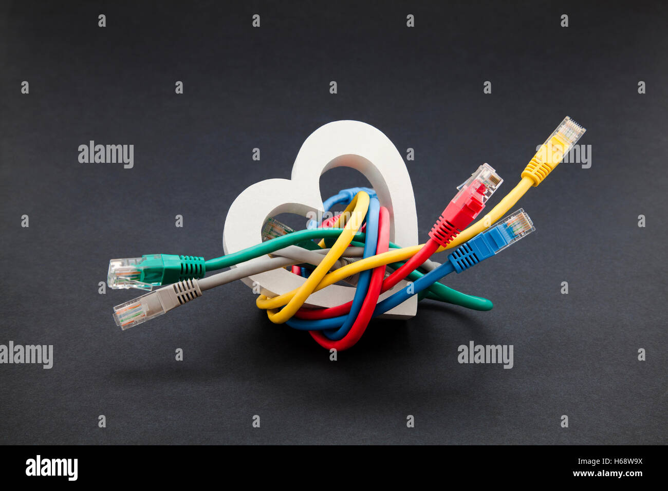Online love and social networking concept. Network cables with heart shape Stock Photo
