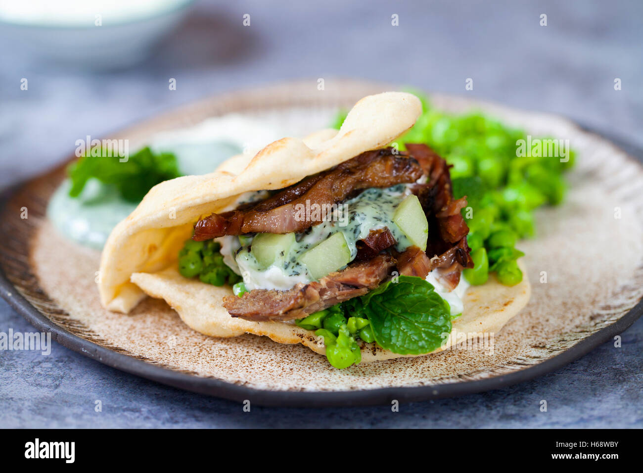 Mini flat breads with crispy lamb, mashed peas, cucumber, mint and yogurt sauce Stock Photo