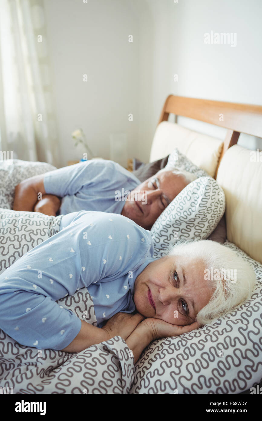 Senior woman awake on bed Stock Photo