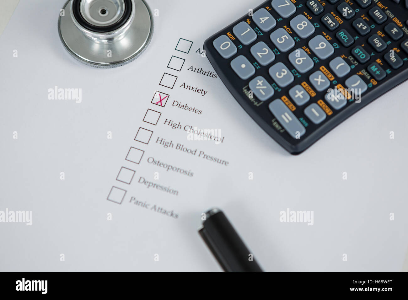 Close-up of health evaluation form with diabetes check and calculator, stethoscope Stock Photo