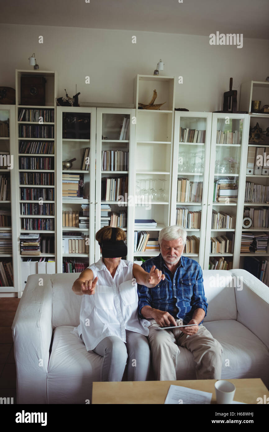 Senior couple using digital tablet and virtual reality headset Stock Photo