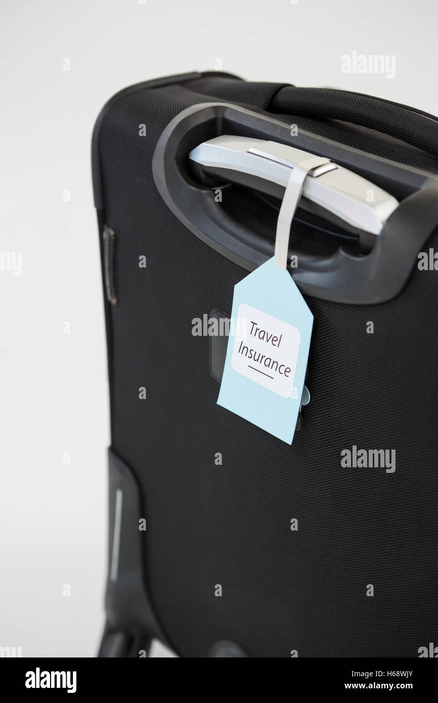 Travel insurance label tied to a suitcase Stock Photo