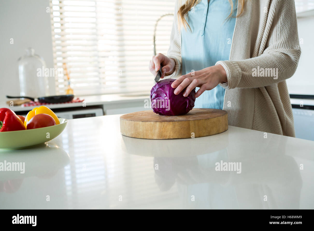 Mid section of woman cutting red cabbage in kitchen Stock Photo