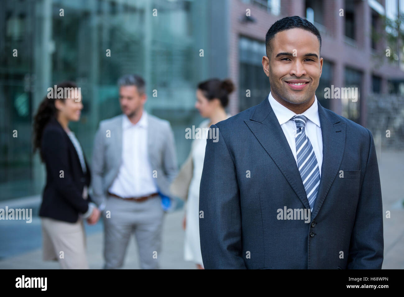 Smiling businessman standing in office building Stock Photo