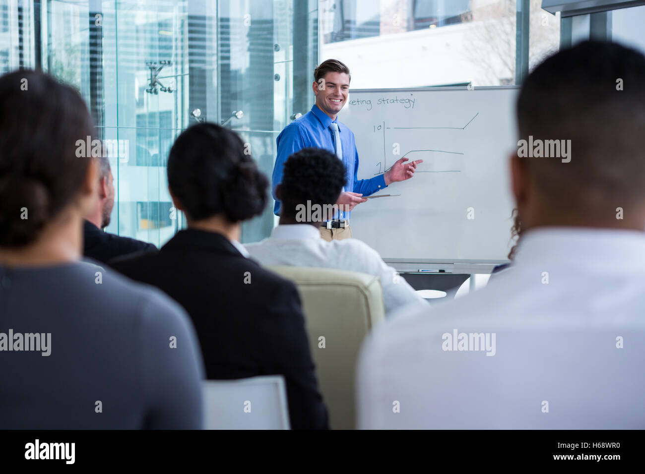 Businessman discussing on white board with coworkers Stock Photo