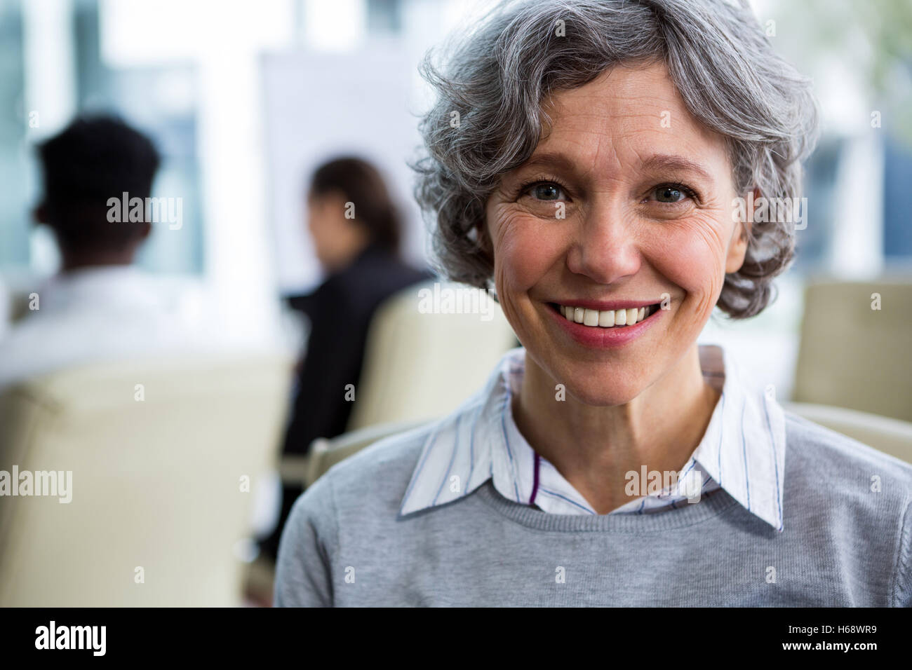 Smiling businesswoman sitting in office Stock Photo