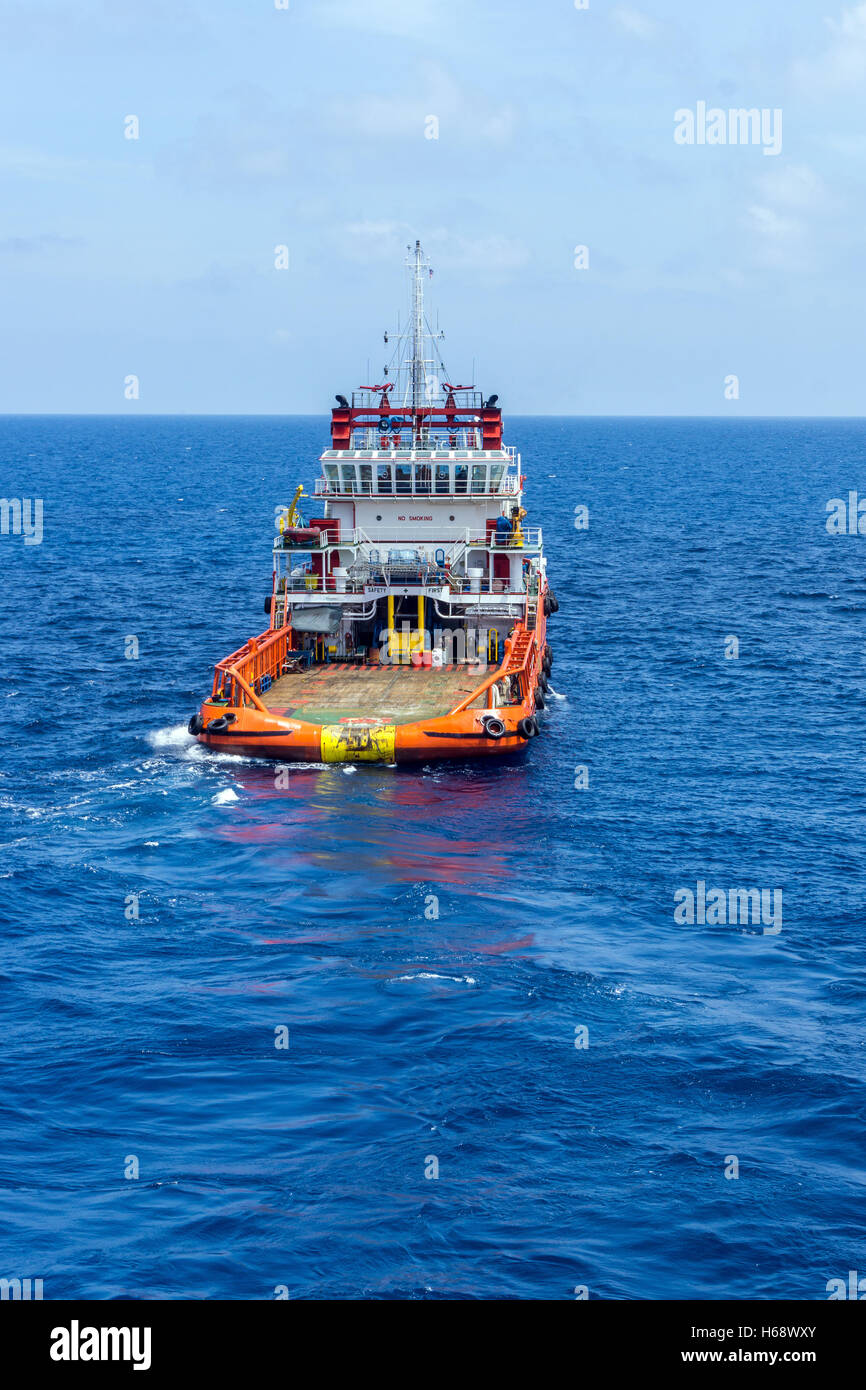 Anchor handling tug deploying anchors of construction barge at oilfield