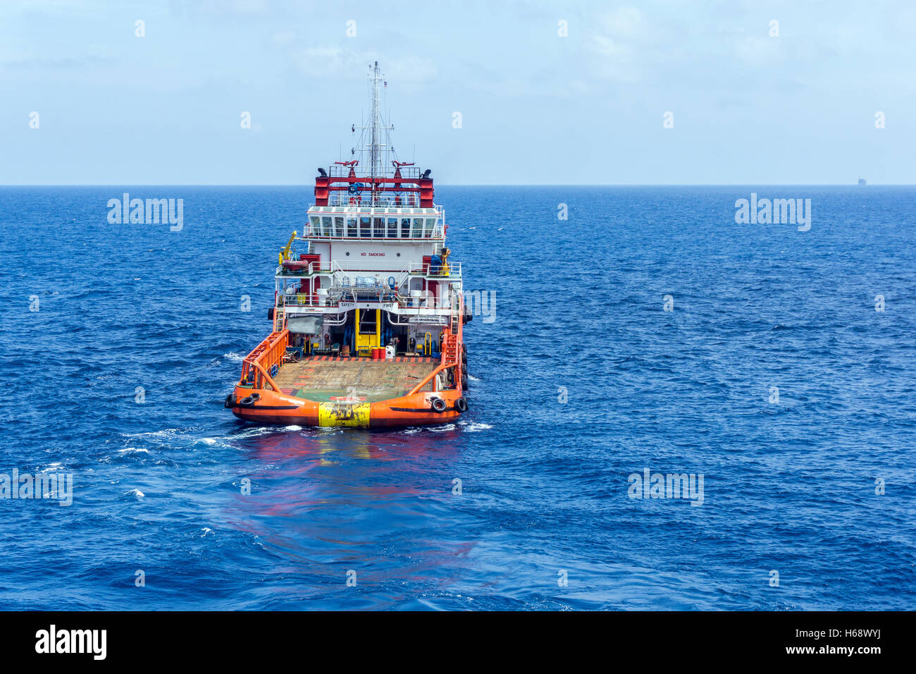 Anchor handling tug deploying anchors of construction barge at oilfield Terengganu, Malaysia Stock Photo
