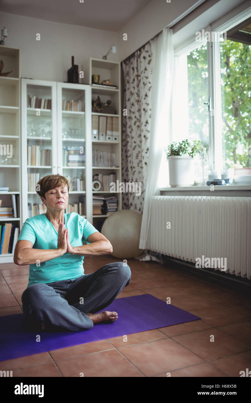 Senior woman meditating in prayer position Stock Photo