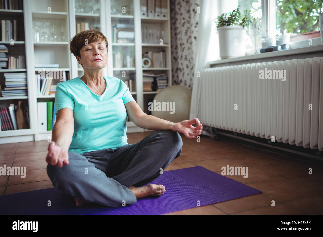 Senior woman meditating in lotus position Stock Photo