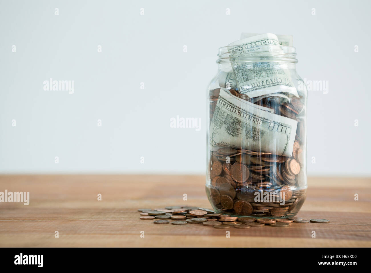 Close-up of coins and currency notes in jar Stock Photo