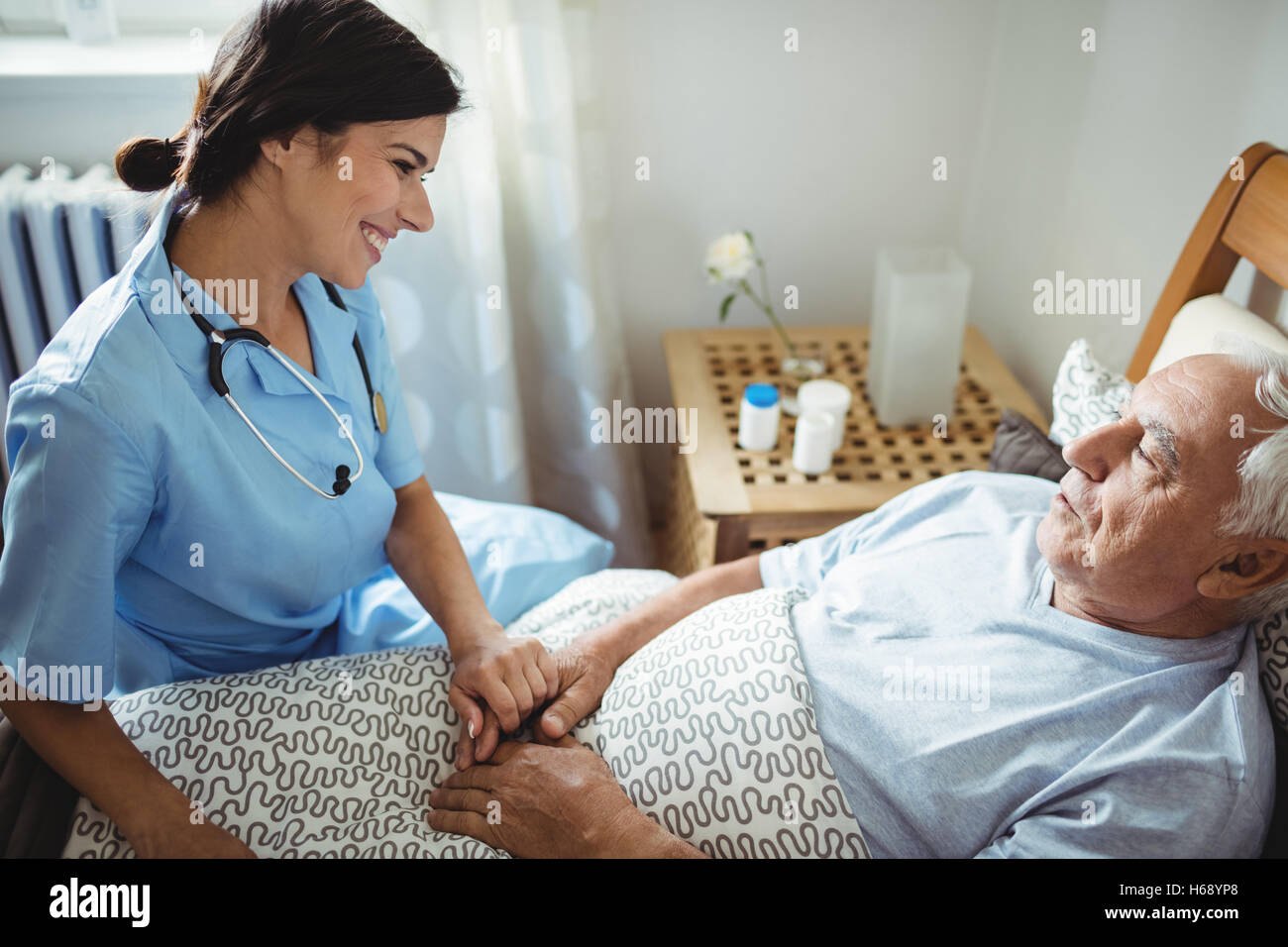 Nurse holding hands of senior man Stock Photo