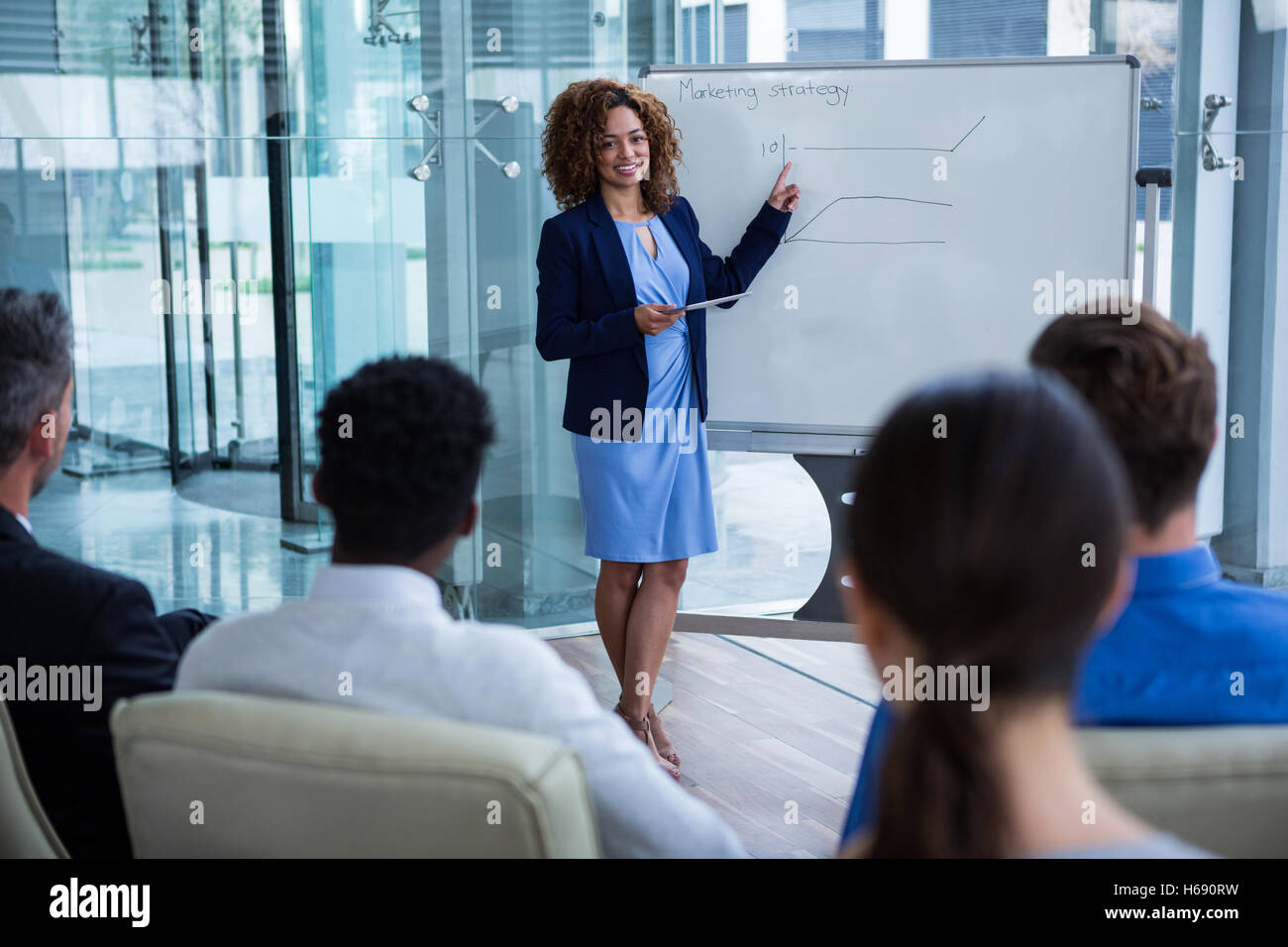 Businesswoman discussing on white board with coworkers Stock Photo