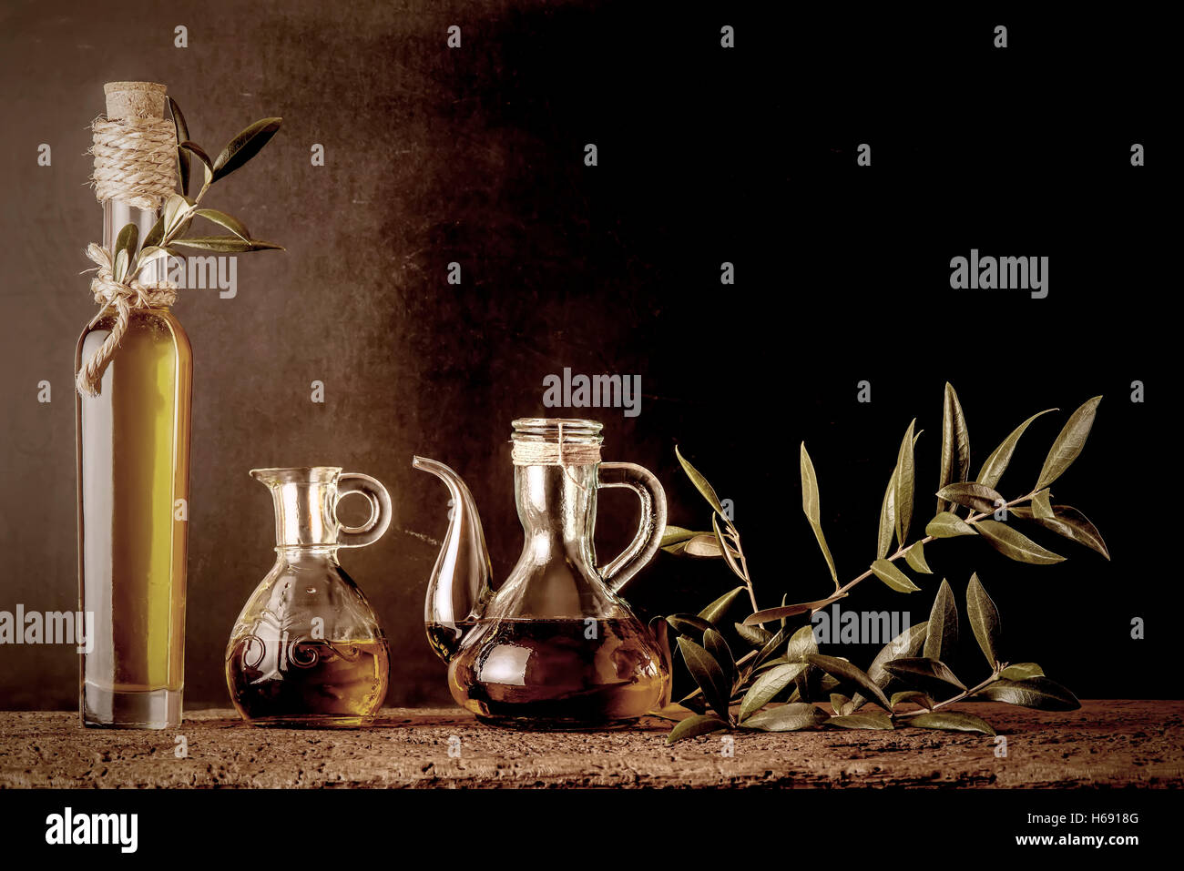 Bottle and glass jars of extra virgin olive oil on rustic background ...