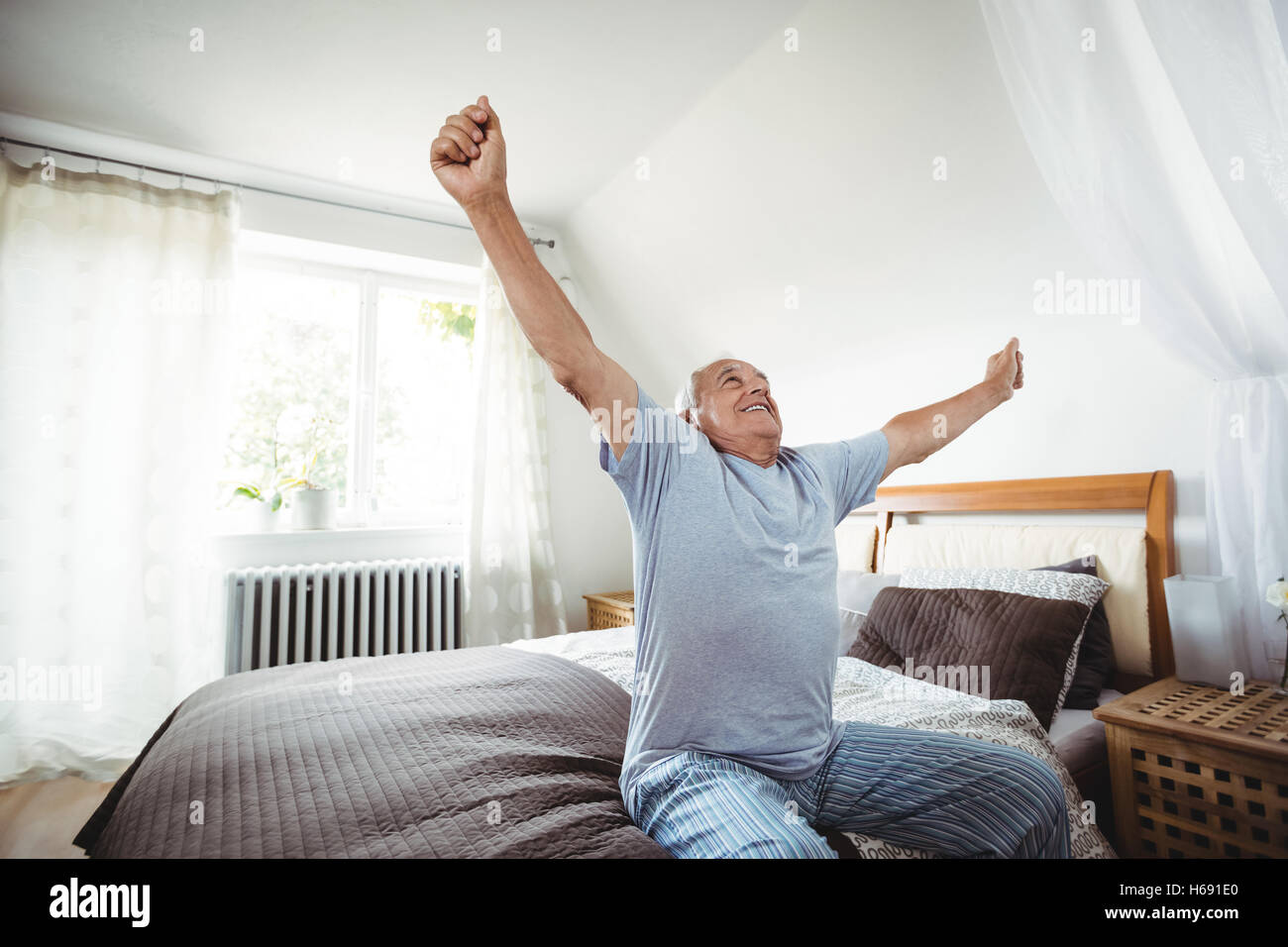 Senior man yawning on bed Stock Photo - Alamy