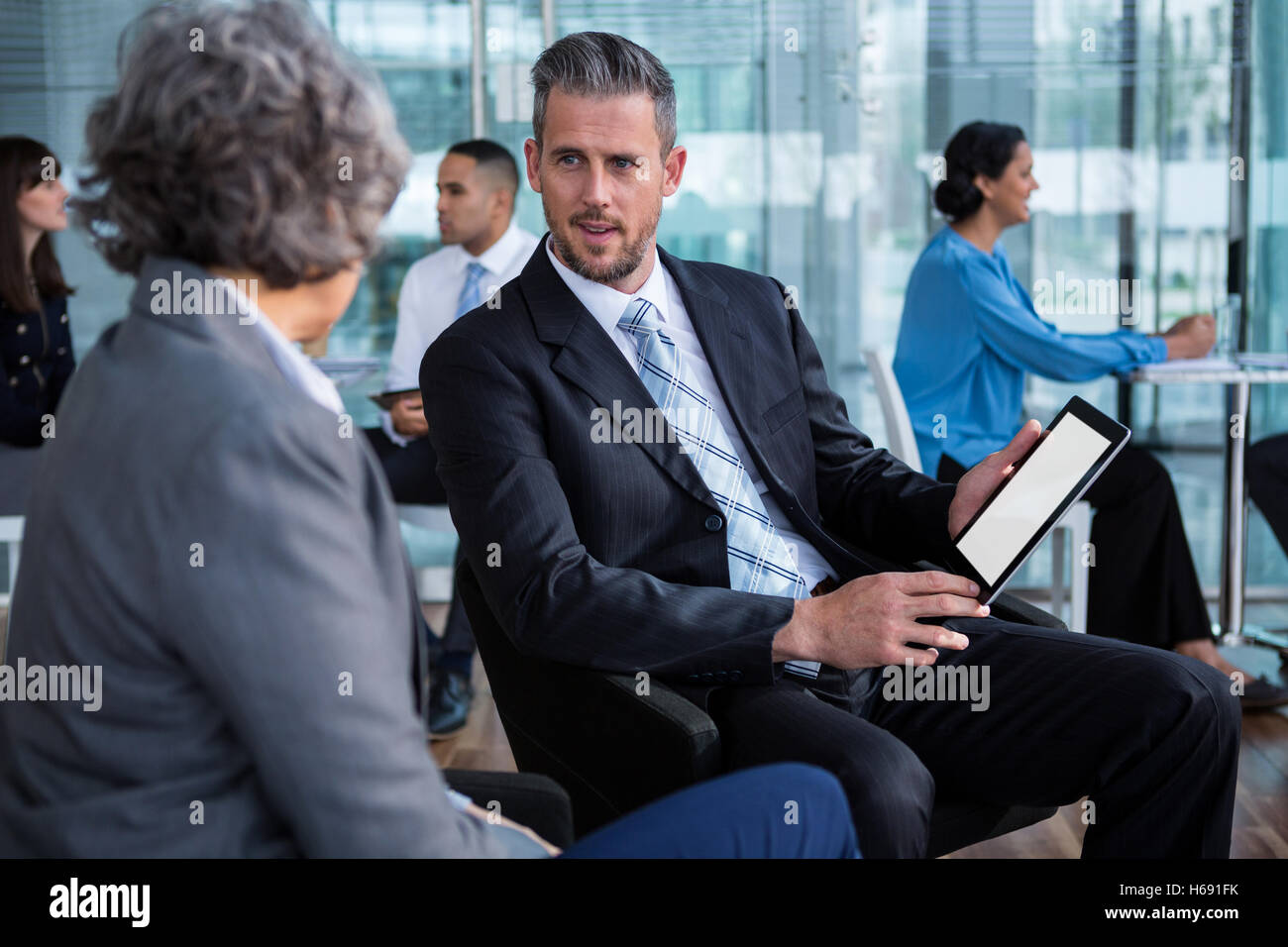 Businesspeople having discussion over digital tablet Stock Photo