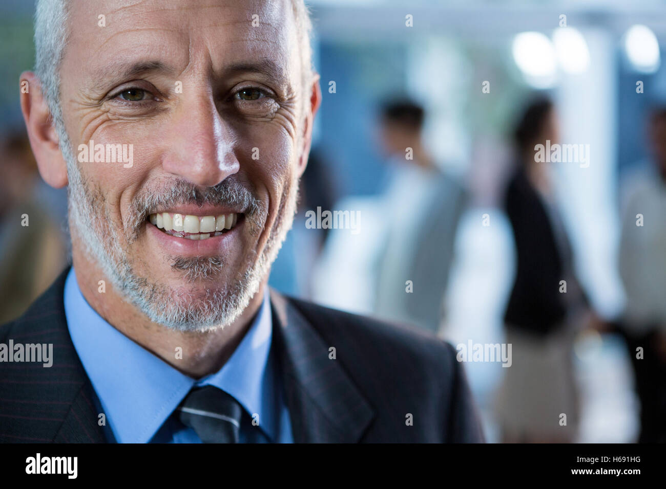 Smiling businessman standing in office Stock Photo - Alamy