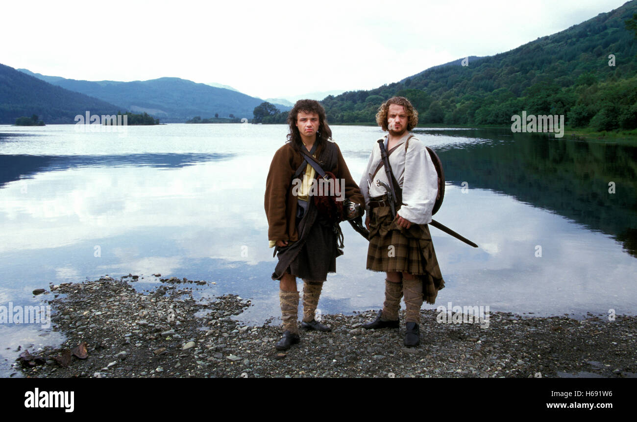 Two actors dressed as Scottish clan members in old Highland Scottish dress on the shores of Loch Lomond, Scotland. Stock Photo